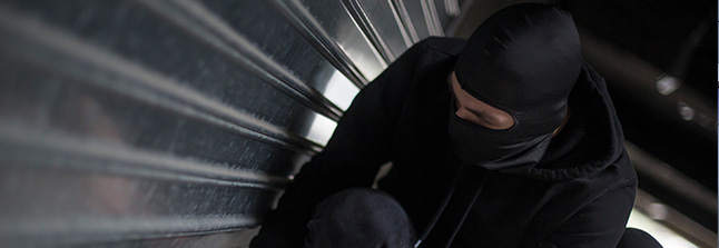 burglar attempting to break into garage door 